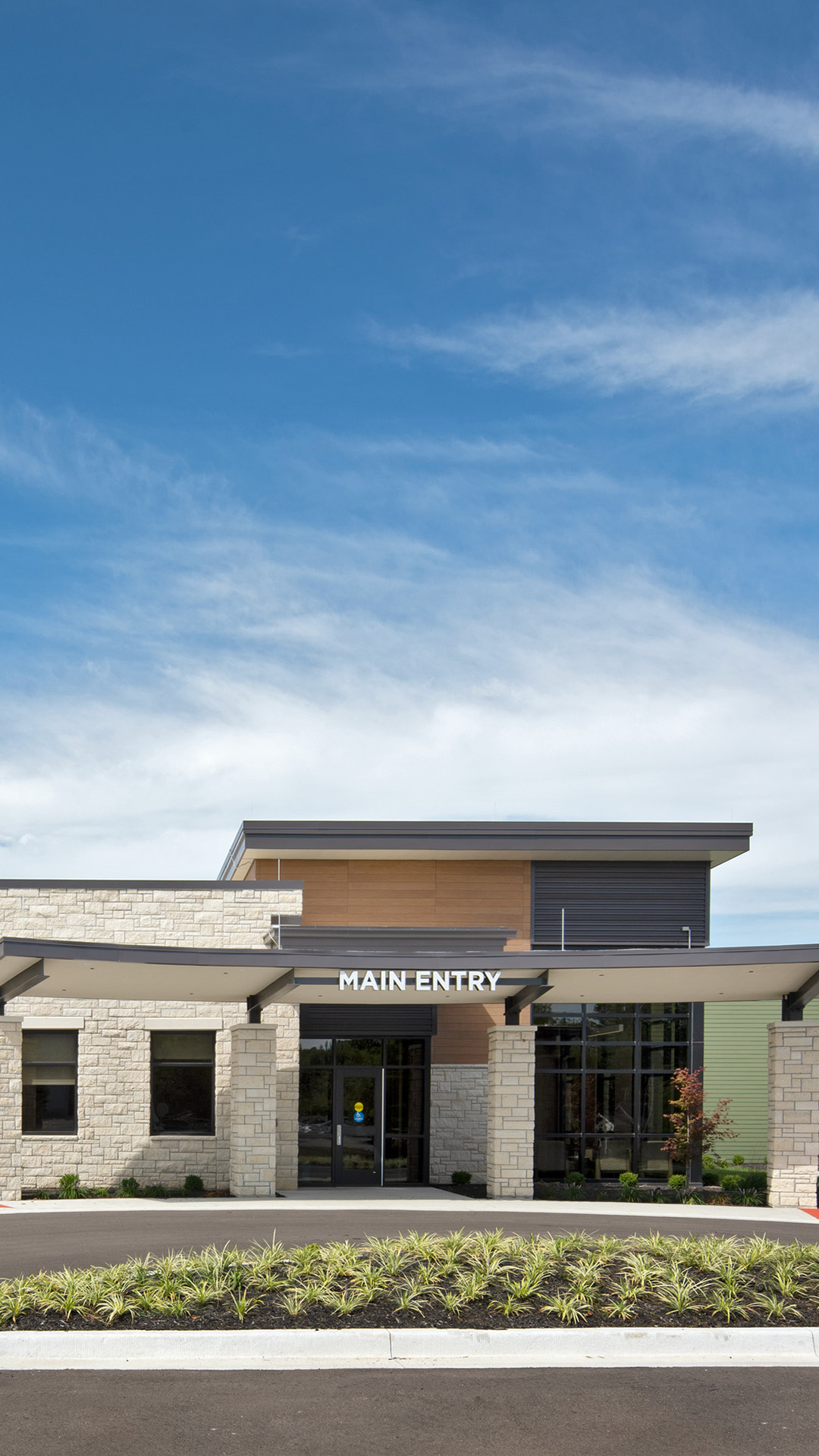 A mobile-friendly version of the Douglas County Crisis Center, highlighting a building designed for accessibility. The structure is a mix of traditional and modern architectural elements, with a focus on functionality and ease of access. The exterior features a clear entry path and large windows.