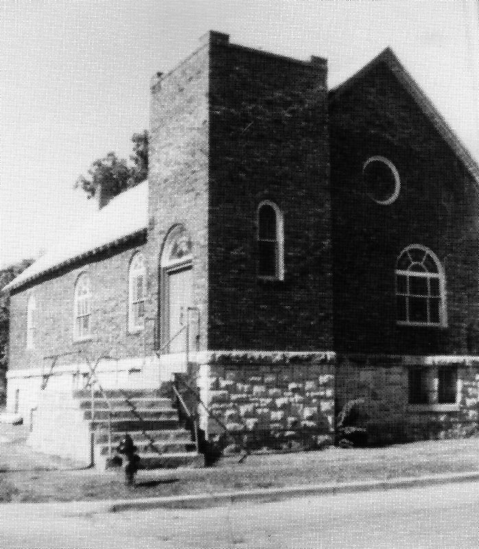 Black and white historic photo of a brick and stone church.
