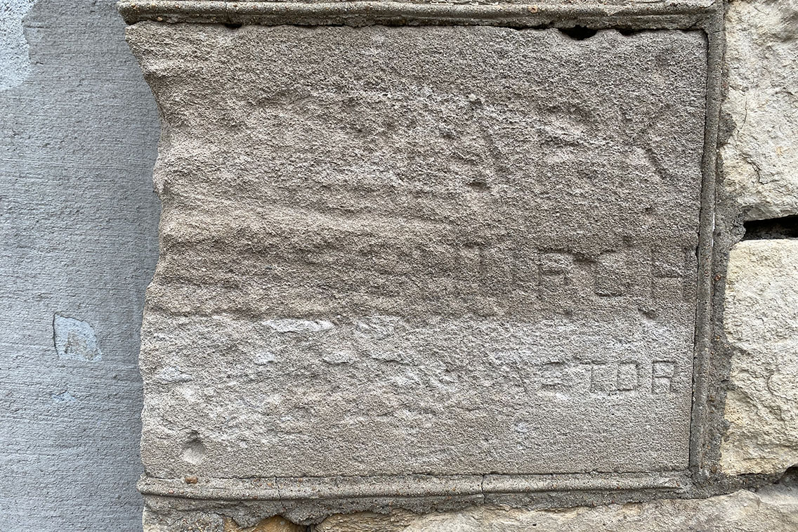 Photo featuring a deteriorated and unreadable cornerstone before replacement.