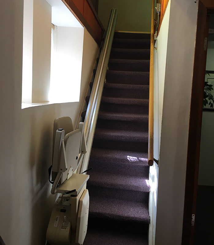 Photo featuring a church's stair and chair lift before replacement.