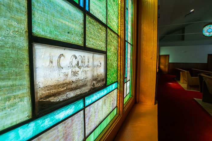 Photo of stained-glass window featuring the retained flood line from a historic flood.