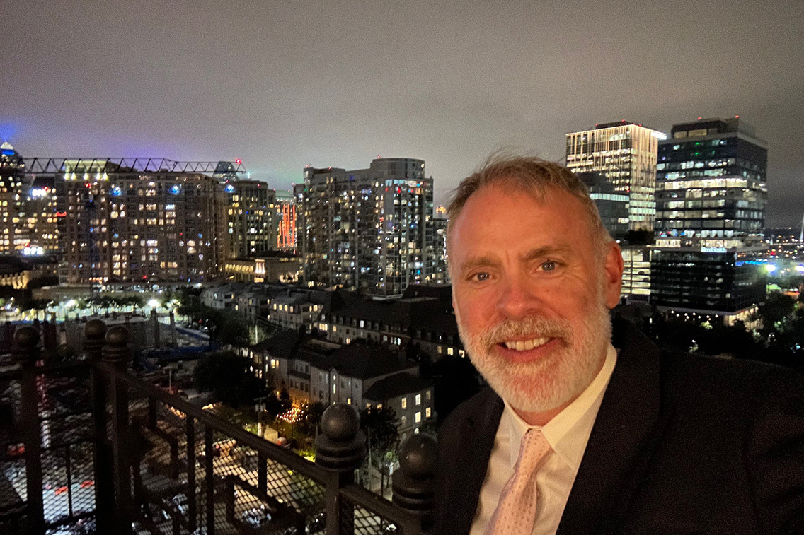 A man taking a selfie in front of the Dallas skyline