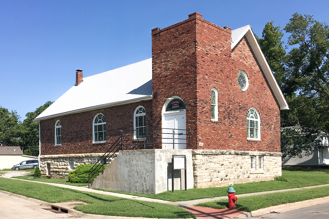 A photo of the exterior of a brick and stone church before it is rehabilitated.