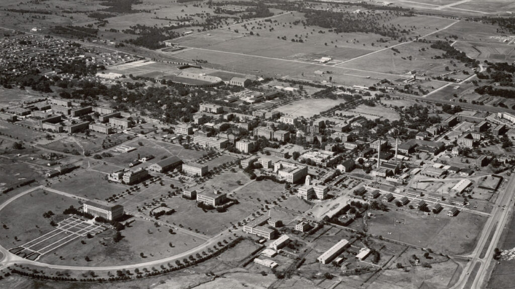Historic aerial view of Texas A&M University campus with early academic buildings and open landscapes.