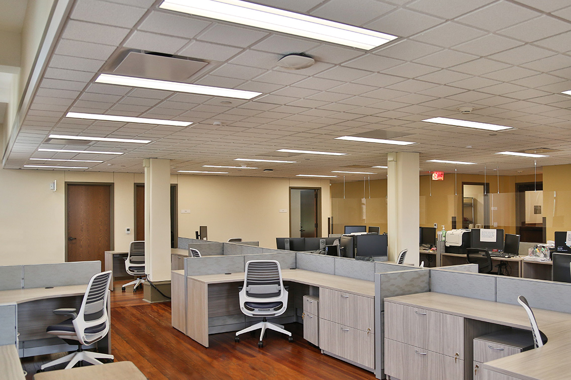 Open office space in Nagle Hall with restored wood floors, modern workstations, and collaborative layout.