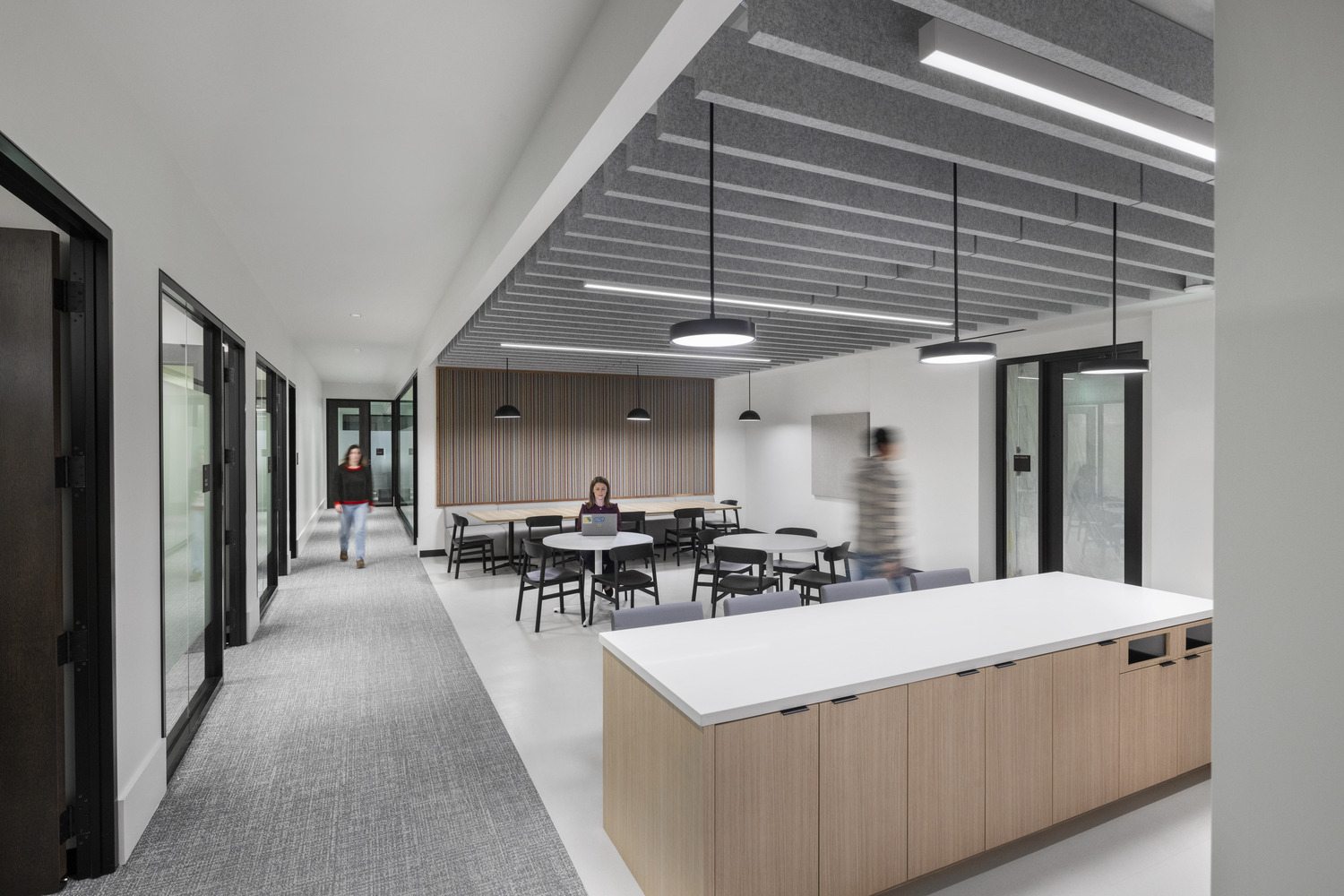 Renovated interior of the Jesse Unruh State Office Building featuring a modern employee break area, seating, and glass-walled offices.